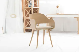 Wooden armchair with upholstered seat in a bright studio setting