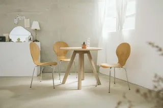 Dining table and three wooden chairs in a bright interior