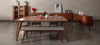 Wood dining table, chairs, sideboard and shelving styled in a modern interior