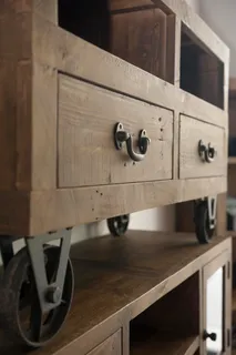 Rustic wooden storage cabinet with drawers, metal wheels and open shelving