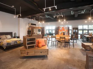 Furniture showroom displaying beds, tables, cabinets and wooden seating