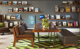 Hospitality lounge with wooden table, chairs, shelving and bench