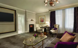 Finished hospitality room with sofa, armchairs, coffee table and media unit