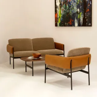 Brown upholstered lounge seating and round coffee table in a studio