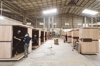 Workers assembling wooden cabinets inside a furniture factory