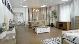 Furniture showroom with dining set, cabinets, bed and living room pieces.