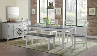 White dining table and chairs with a sideboard in a furnished room.