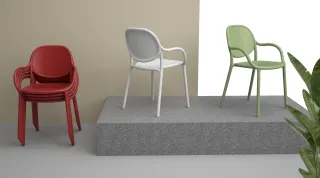 Red, white, and green molded chairs displayed on a platform