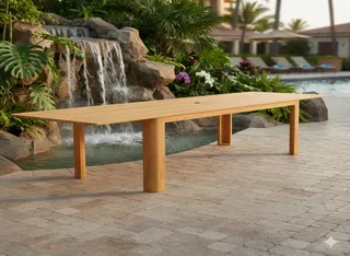 Large rectangular wooden outdoor dining table beside a waterfall pool
