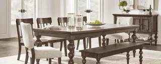 Dark wood dining table with upholstered chairs, bench and matching sideboard.