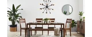 Dark wood dining table and chairs with matching sideboard in a bright room.