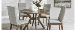 Round wood dining table with four upholstered dining chairs.