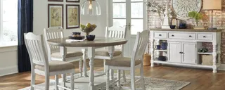 Round white dining table with four chairs and matching sideboard.