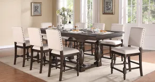 Dark wood dining table surrounded by white upholstered dining chairs.