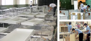 Furniture factory floor with workers assembling white furniture components.