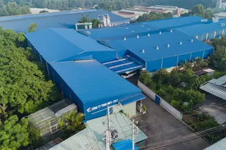 Aerial view of a large blue-roofed furniture manufacturing factory