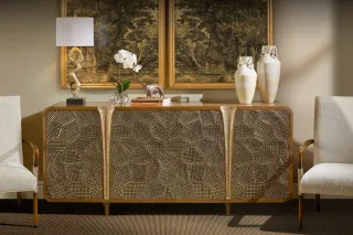 Gold-accented sideboard displayed between two upholstered chairs