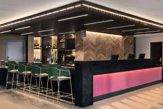 Modern hotel reception and bar area with upholstered chairs