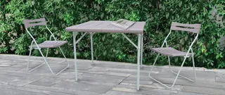 Outdoor folding table and four matching chairs on a paved patio