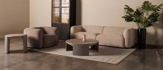 Sofa, armchairs, coffee table and cabinet arranged in a modern living room.