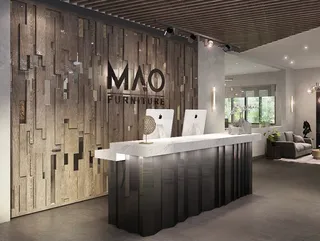 Furniture showroom reception with textured wood wall and white desk
