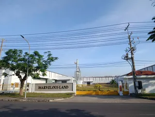 Exterior of the Marvelous Land furniture factory with its sign, entrance and production buildings.