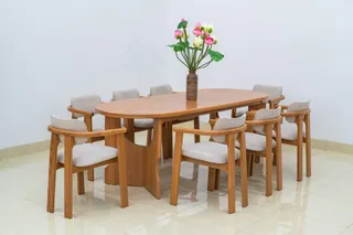 Wooden dining table surrounded by upholstered armchairs