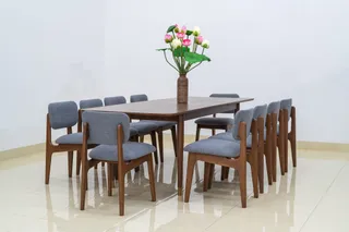 Rectangular wooden dining table surrounded by upholstered wooden chairs