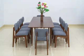 Large wooden dining table surrounded by grey upholstered dining chairs