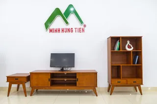 Wooden TV console, display cabinet and side table arranged against a showroom wall
