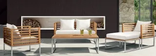 Wooden slat lounge chairs and sofa with white cushions around a metal coffee table.