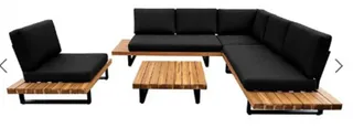 Black outdoor sectional sofa and lounge chair with slatted wooden tables.