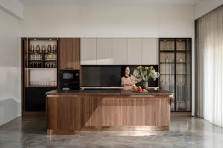 Wood kitchen island with fluted front and surrounding built-in cabinets