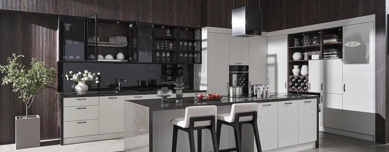 Bright fitted kitchen with island, white cabinets and dark wood wall panels