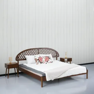 Wooden bed with woven curved headboard and matching bedside tables.