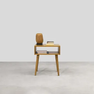 Wooden bedside table with open shelf, tapered legs and woven lamp.