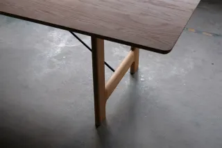 Wooden table with rounded corners, tapered legs and a horizontal support.
