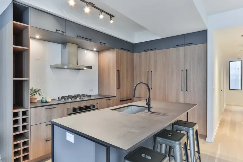 Modern fitted kitchen with gray cabinets, woodgrain doors and central island