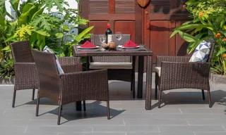 Woven outdoor dining table and four chairs on a tiled patio