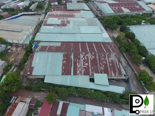Aerial view of a large factory complex with multiple corrugated-roof buildings.