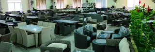 Furniture showroom displaying wicker seating, dining tables, and upholstered chairs