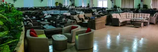 Showroom with wicker sofas, armchairs, tables, and dining furniture