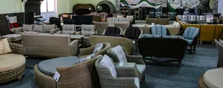 Showroom filled with wicker chairs, sofas, tables, and lounge furniture