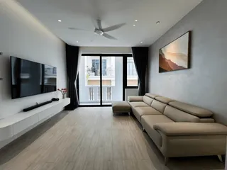 Modern living room with sectional sofa, television wall and balcony doors