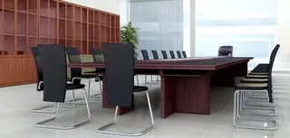 Dark wood conference table surrounded by black upholstered office chairs.