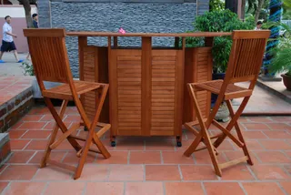 Wooden slatted bar cabinet with two matching bar chairs on a tiled patio