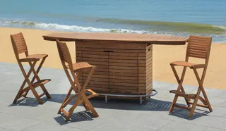 Wooden outdoor bar cabinet and four folding bar chairs on a beach