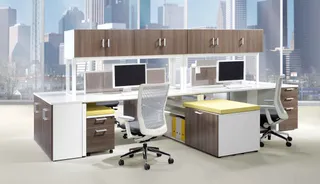 Office workstation cluster with overhead cabinets, desks, monitors and chairs