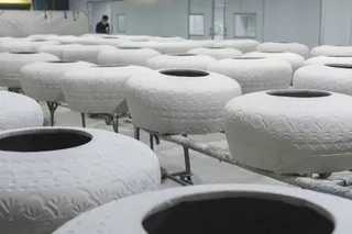 Rows of white textured cylindrical furniture pieces in a production area.