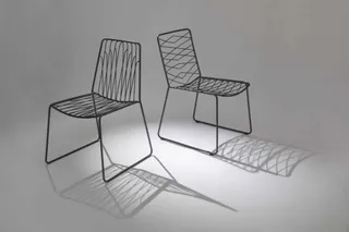 Two open wire-back chairs with geometric metal frames.